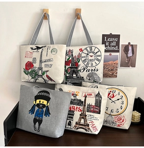 Detail of printed canvas tote bags with vintage Paris designs and striped handles