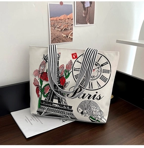 Close-up of cream canvas tote bag with Paris Eiffel Tower print and striped handles