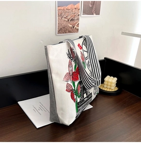 Detail of artistic floral and Eiffel Tower print on a canvas tote with striped handles