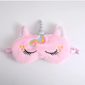 Detail van roze pluche eenhoorn slaapmasker met zilveren hoorn en zachte zijden band