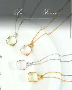Close-up of square gemstone pendants in gold and silver settings on S925 silver chains