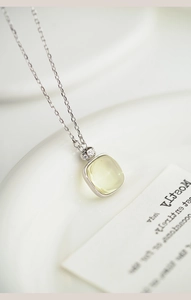 Macro view of S925 silver necklace with square pale yellow gemstone and small diamonds