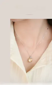 Detail of square amber gemstone pendant on S925 silver chain worn by a model