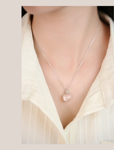Close-up of square pink crystal pendant on S925 silver chain worn by a model