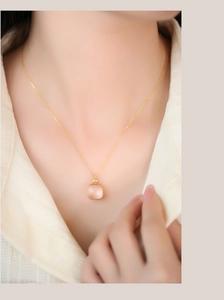 Detail of S925 silver necklace with pink square crystal pendant on woman's neck