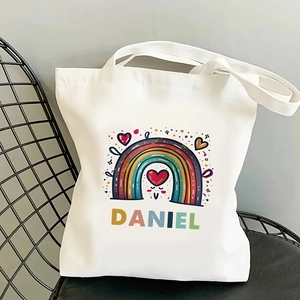 Detailed shot of white canvas tote bag featuring rainbow print and custom Daniel name