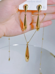 Detail view of a gold-plated stainless steel teardrop necklace and earrings jewelry set
