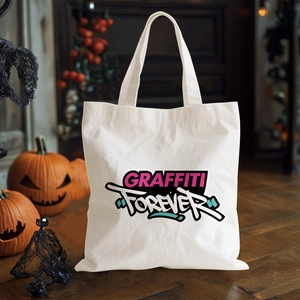 Close-up of white canvas tote bag with GRAFFITI FOREVER print and pumpkin decor