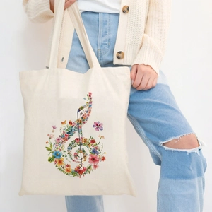 Canvas tote bag featuring a colorful floral treble clef print held by a model
