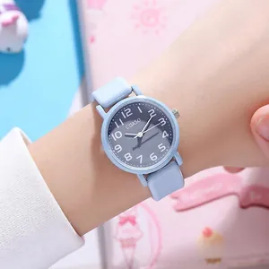 Close-up of sky blue quartz watch worn on wrist with minimalist gray dial and white numbers