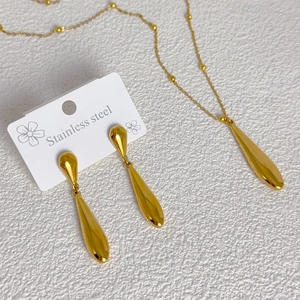 Golden stainless steel jewelry set featuring polished teardrop earrings and beaded necklace