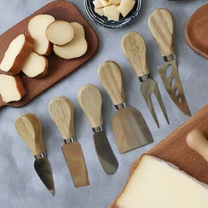 6-piece stainless steel cheese knife set with wooden handles on light linen tablecloth