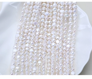 Close-up of irregular natural baroque freshwater pearls on white textured ceramic