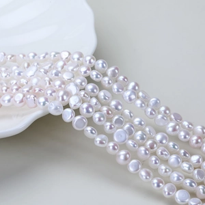Irregular natural freshwater baroque pearl strands displayed on a white shell plate