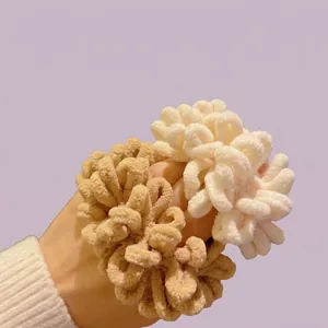 Close-up of plush cream and brown scrunchies showing soft textured fabric and fluffy design