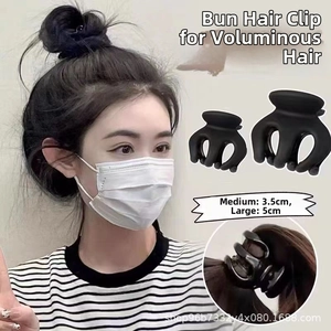Detail view of medium 3.5cm and large 5cm matte black hair claw clips for bun styling
