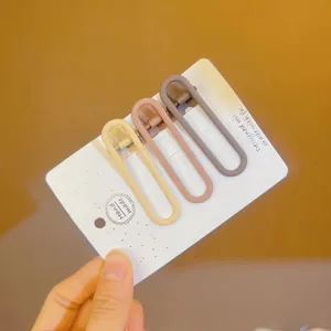 Three-piece U-shaped matte hair clips in beige, pink, and coffee on a white display card