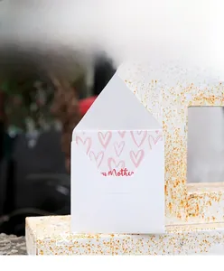 Close-up of minimalist Mother's Day card with heart pattern and white envelope