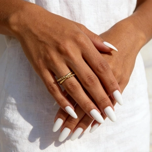 Double-layered gold titanium steel ring with micro-bead texture on model finger