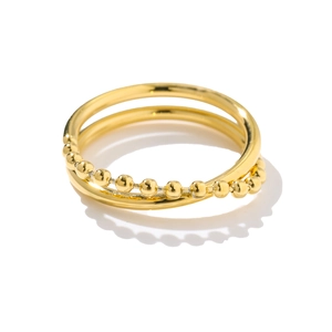 Detail of a double-layered gold titanium ring featuring smooth and beaded interlocking bands