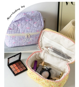 Detail of quilted cosmetic bag showing interior mesh pocket and pink bow pattern