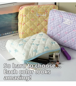Detailed view of quilted makeup bags with floral and bow patterns in various colors