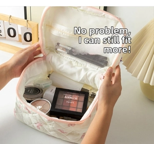 Detailed interior of a floral quilted makeup bag showing large capacity and mesh pocket