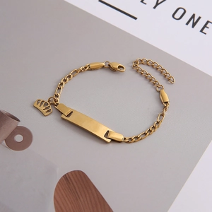 Detail of 18K gold plated stainless steel bracelet with blank ID tag and crown charm