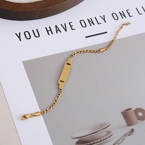 Detailed macro view of 18K gold-plated stainless steel ID bracelet with Figaro chain