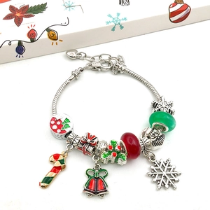 Macro detail of Christmas advent calendar charm bracelet with festive enamel pendants