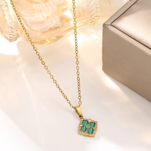 Detailed close-up of a vintage clover necklace with malachite inlay and golden flower