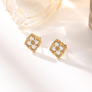 Macro shot of 18K gold plated leaf earrings with white inlay and beaded edge detail
