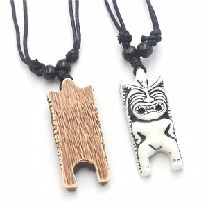 Macro view of tribal Tiki resin pendants with detailed wood texture and woven rope cord
