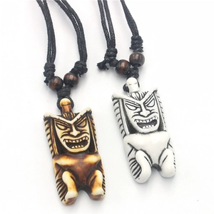 Close-up of Tiki tribal pendants in brown and white resin with adjustable cords