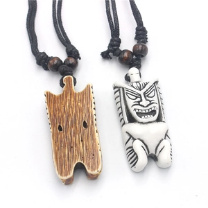 Detail of Tiki pendant necklaces in wood texture and white resin on black woven cord