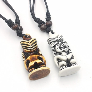 Detail of Polynesian Tiki necklaces with carved brown and white pendants on braided cords