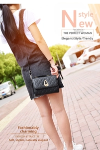 Side view of black quilted crossbody bag with golden teardrop buckle on a model