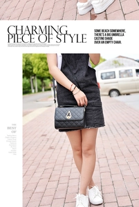 Detail of black quilted shoulder bag featuring a golden water-drop clasp and premium texture