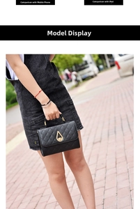 Outdoor model holding a black quilted handbag with a gold teardrop-shaped metal lock