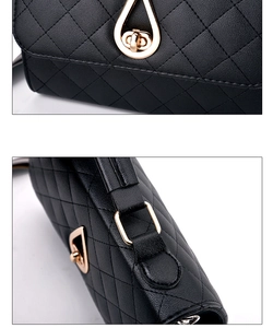 Detail of black quilted leather shoulder bag with gold teardrop-shaped twist lock buckle