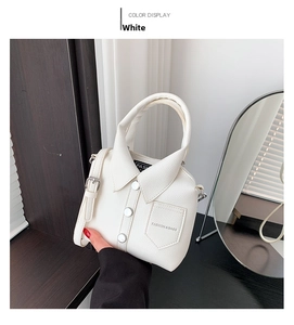 Unique white shirt-shaped handbag with collar details and adjustable strap shown in hand