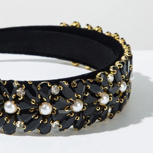 Close-up of black velvet headband with floral pattern of dark gems and white pearls
