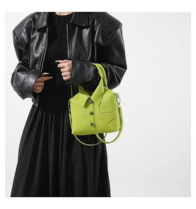 Detail of green shirt-shaped leather bag with silver buttons and fashion logo