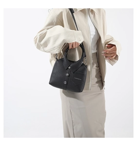 Detail of black crossbody bag featuring creative shirt collar design and lychee leather texture