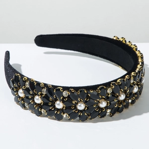 Close-up of baroque headband with black crystals and white pearls on velvet base