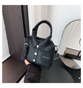 Detail of creative black shirt-style handbag showing lychee leather and metal buttons