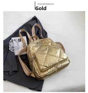 Details des goldenen gesteppten Rucksacks mit Metallic-Finish auf grauem Anzug
