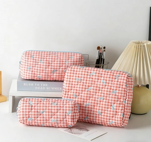 Detailed set of three red checkered quilted storage bags with blue bow embroidery