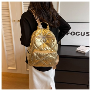 Rückansicht des goldenen gesteppten Metallrucksacks, getragen von einem Modell