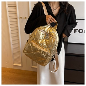 Detailansicht eines metallisch goldenen Stepprucksacks mit stilvollem Rautensteppmuster